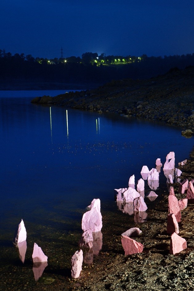 Foto nocturna Pantano Intervención Artistica de piedras rosas incadas en la orilla